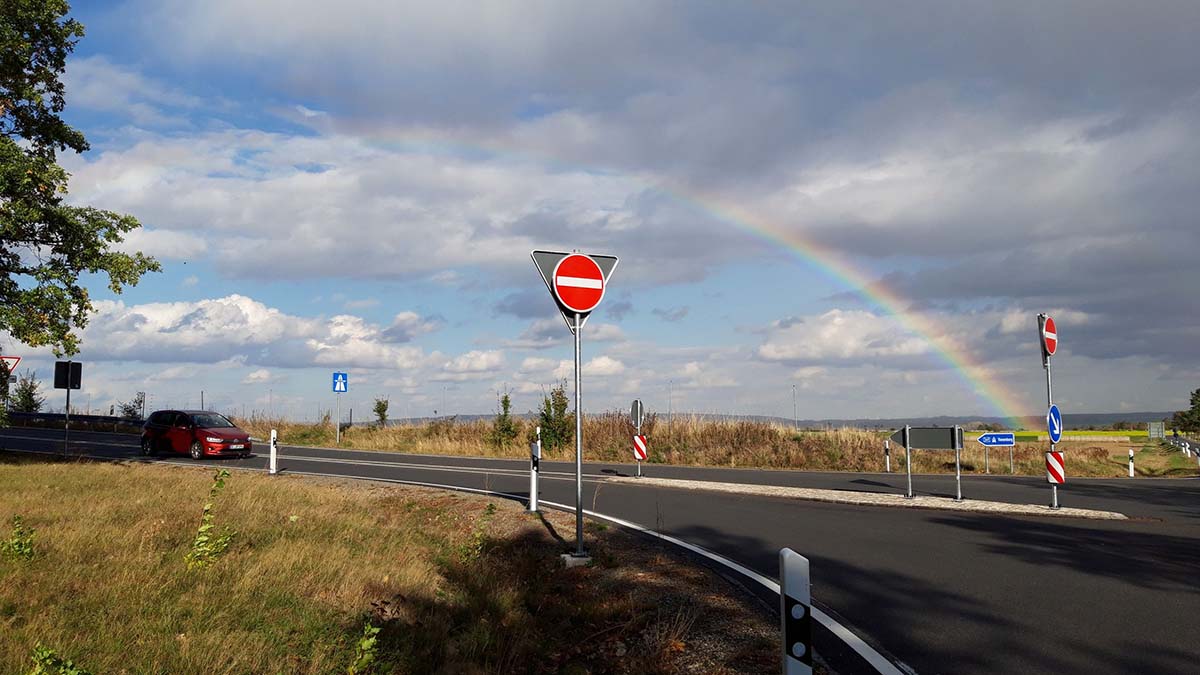 Verkehrsschild und Regenbogen